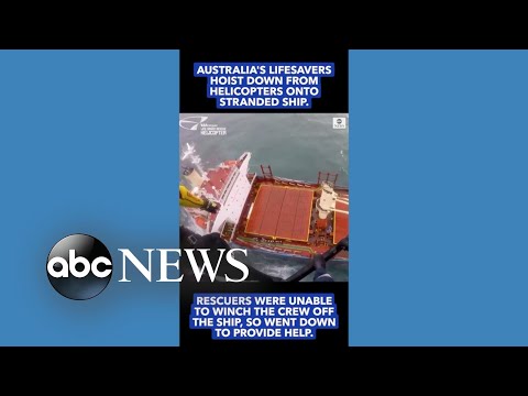 Helicopter lowers rescuers onto stricken ship