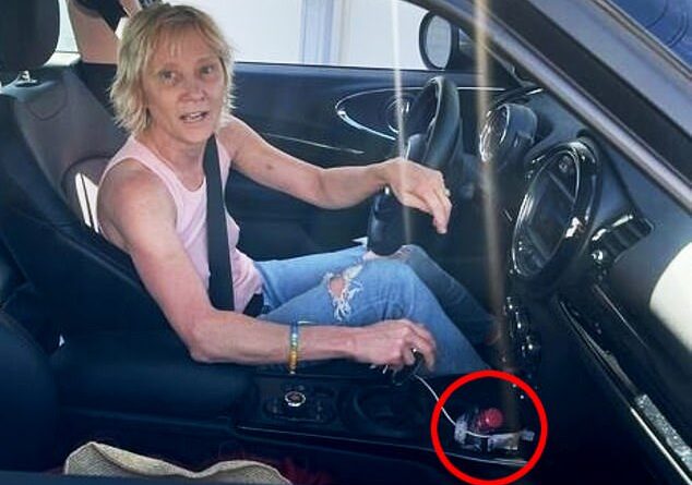A photo before the Aug. 5 crash shows Heche moments before the second crash behind the wheel with a bottle of vodka in the cup holder
