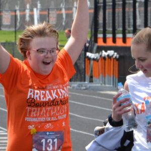 A runner crosses the finish line during the KHS adaptive triathlon.