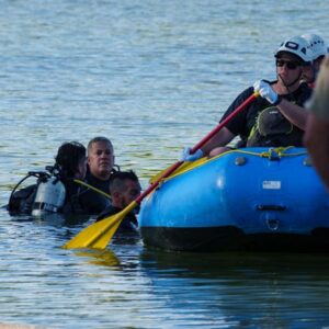 The Maricopa County Sheriff's Office and the Mesa Fire and Medical Department appear to transport a body to the water's edge of the lake at Dobson Ranch Park after a drowning was reported and conducted a water search and rescue operation on May 6, 2023.