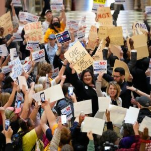 May 10, 2023;  Columbus, Ohio, USA;  House Minority Leader Allison Russo speaks to protesters in the rotunda of the Ohio Statehouse with other Democratic representatives holding hand-drawn signs on manila folders chanting