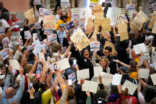 May 10, 2023;  Columbus, Ohio, USA;  House Minority Leader Allison Russo speaks to protesters in the rotunda of the Ohio Statehouse with other Democratic representatives holding hand-drawn signs on manila folders chanting