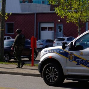 A Louisville Metro police officer walks toward the scene of an active shooting in downtown Louisville, Ky. (Spectrum News 1/Mason Brighton)