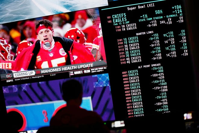 A person gambles as NFL football Super Bowl betting odds are displayed on monitors at the Circa Resort and Casino sportsbook Friday, Feb. 3, 2023, in Las Vegas.