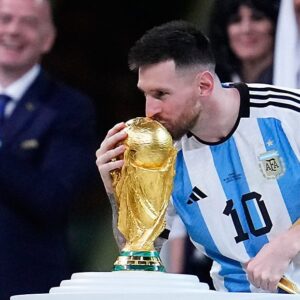 Argentina's Lionel Messi kisses the World Cup trophy after receiving the Golden Ball award for best player of the tournament during the awards ceremony after Argentina defeated France in the World Cup final soccer match at the Lusail Stadium in Lusail, Qatar, Sunday, Dec. 18, 2022. (AP Photo/Natacha Pisarenko)