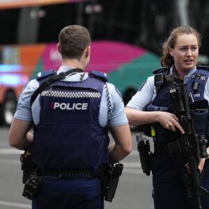 Armed New Zealand police officers stand outside a hotel housing a team from the FIFA Women's World Cup in the central business district following a shooting in Auckland, New Zealand, Thursday, July 20, 2023. New Zealand police are responding to reports that a gunman has fired shots in a building in downtown Auckland. (AP Photo/Abbie Parr)