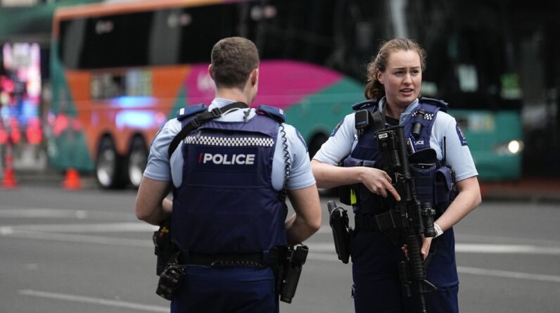 Armed New Zealand police officers stand outside a hotel housing a team from the FIFA Women's World Cup in the central business district following a shooting in Auckland, New Zealand, Thursday, July 20, 2023. New Zealand police are responding to reports that a gunman has fired shots in a building in downtown Auckland. (AP Photo/Abbie Parr)